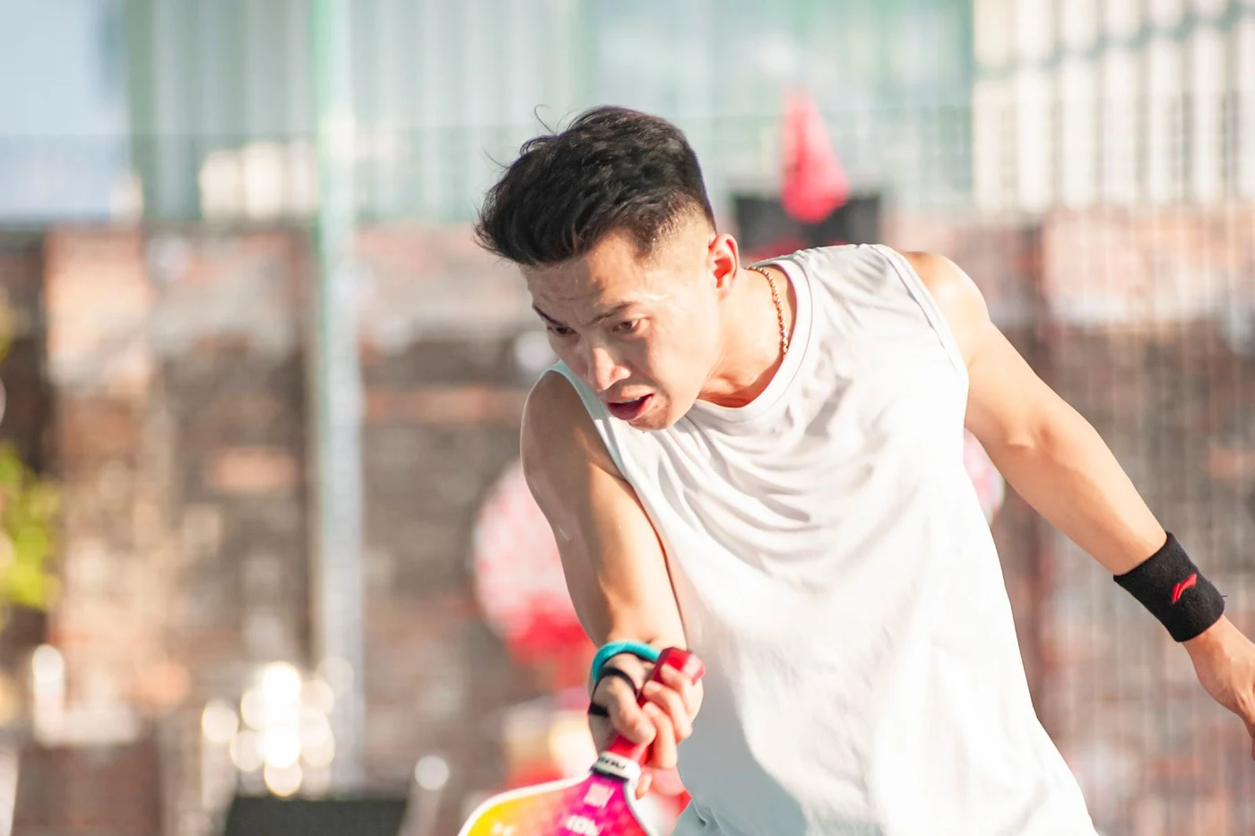A player reaching for a return during an outdoor pickleball session