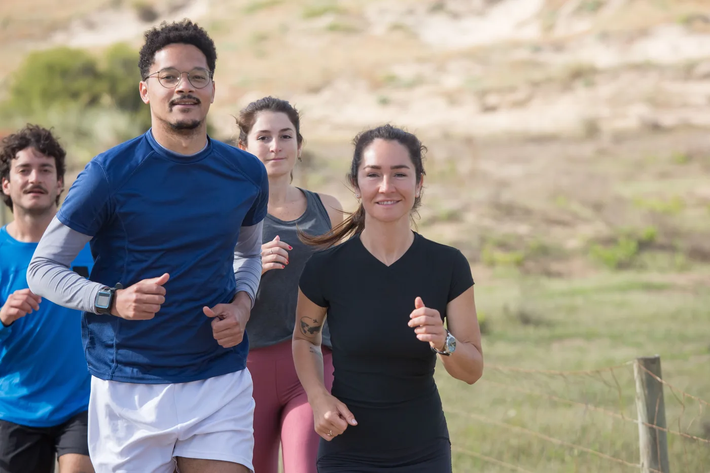 A diverse group of friends jogging together outdoors as part of a regular sports group